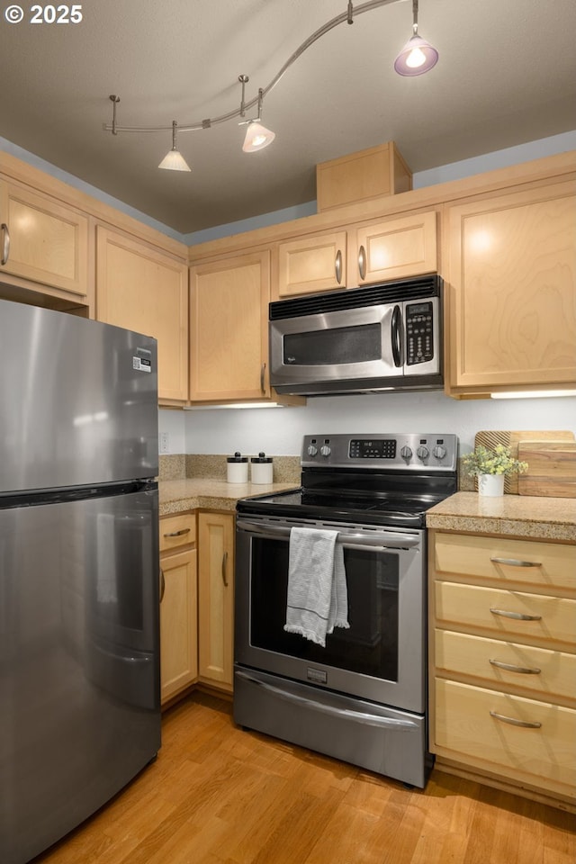 1500 SW Park Ave Unit 429, Portland, OR 97201 - kitchen featuring appliances with stainless steel finishes, light brown cabinetry, light wood-style flooring, and tile counters