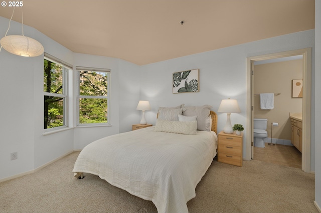 1500 SW Park Ave Unit 429, Portland, OR 97201 - bedroom featuring light carpet, ensuite bathroom, and baseboards