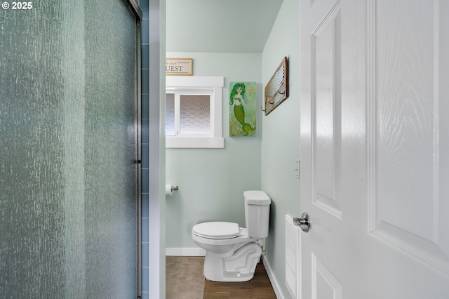 bathroom with toilet and a shower with door