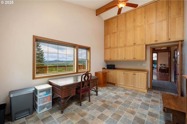 interior space with built in desk, vaulted ceiling with beams, light brown cabinetry, and ceiling fan