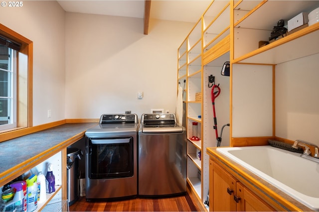 laundry room featuring dark wood-type flooring, washer and clothes dryer, and sink