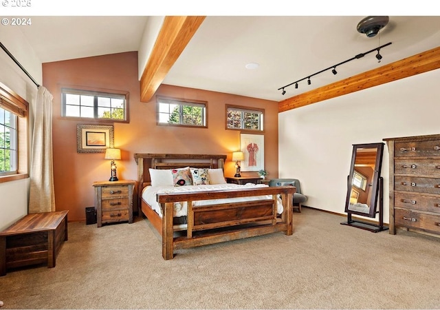 bedroom with light colored carpet, track lighting, multiple windows, and vaulted ceiling with beams