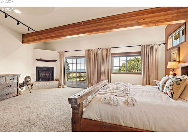 bedroom featuring track lighting, beam ceiling, access to exterior, and carpet flooring