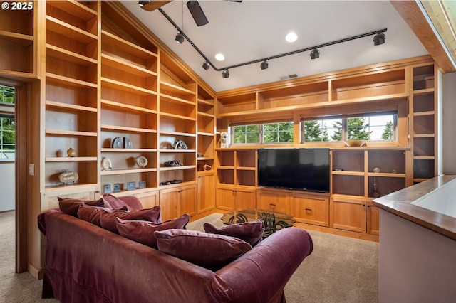 living room with built in shelves, vaulted ceiling, and plenty of natural light