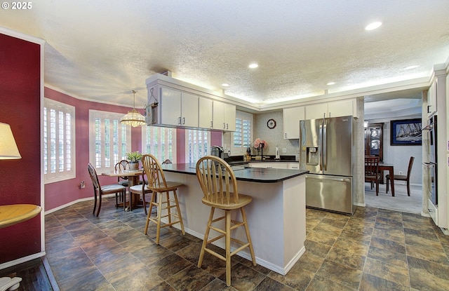 10535 SW 135th Ave, Beaverton, OR 97008 - kitchen featuring stainless steel fridge with ice dispenser, dark countertops, a peninsula, a textured ceiling, and stone finish flooring