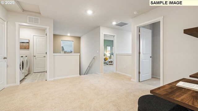 interior space featuring light carpet and washing machine and dryer