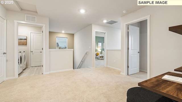 interior space with washer and dryer, visible vents, and light carpet