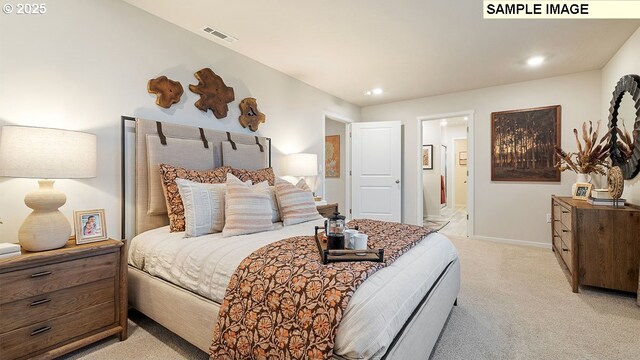 bedroom featuring light carpet and ensuite bath