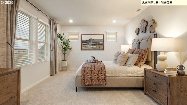 bedroom with visible vents, light carpet, multiple windows, and baseboards