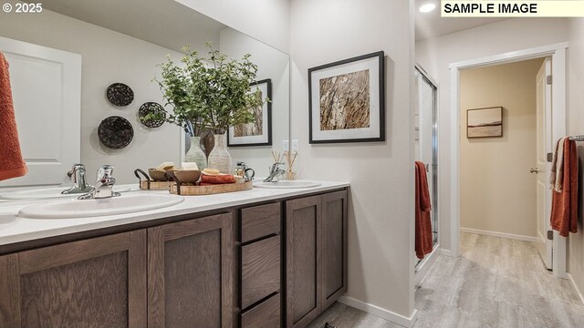 bathroom featuring vanity, wood-type flooring, and walk in shower