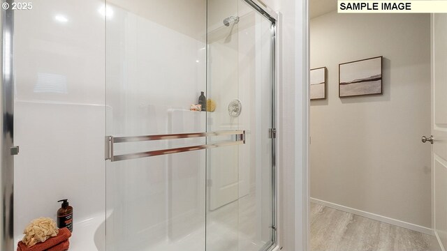 bathroom featuring hardwood / wood-style floors and a shower with shower door