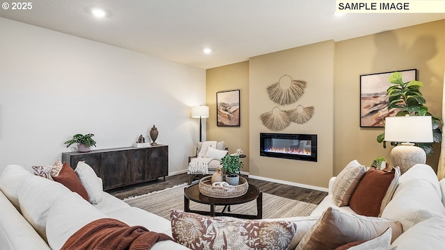 living area featuring recessed lighting, baseboards, wood finished floors, and a glass covered fireplace