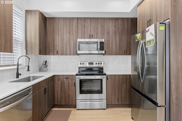 7557 N Gilbert Ave, Portland, OR 97203 - kitchen featuring appliances with stainless steel finishes, light countertops, and backsplash