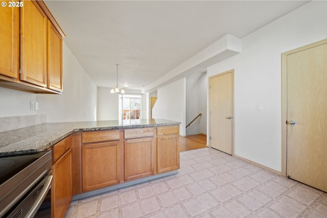 kitchen with stainless steel electric stove, kitchen peninsula, light stone countertops, and a notable chandelier