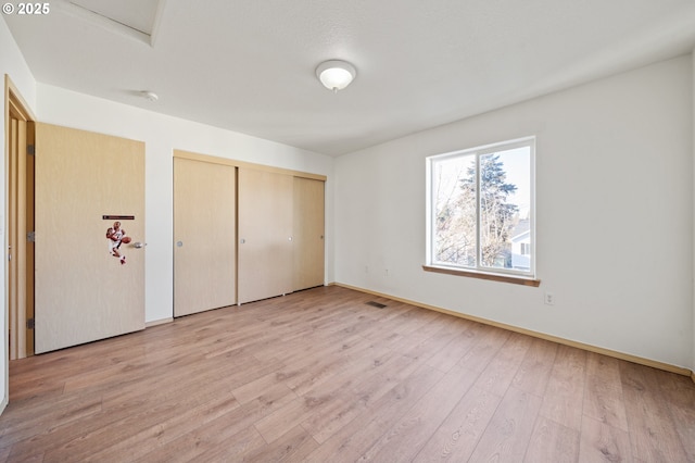 unfurnished bedroom with light hardwood / wood-style floors and a closet