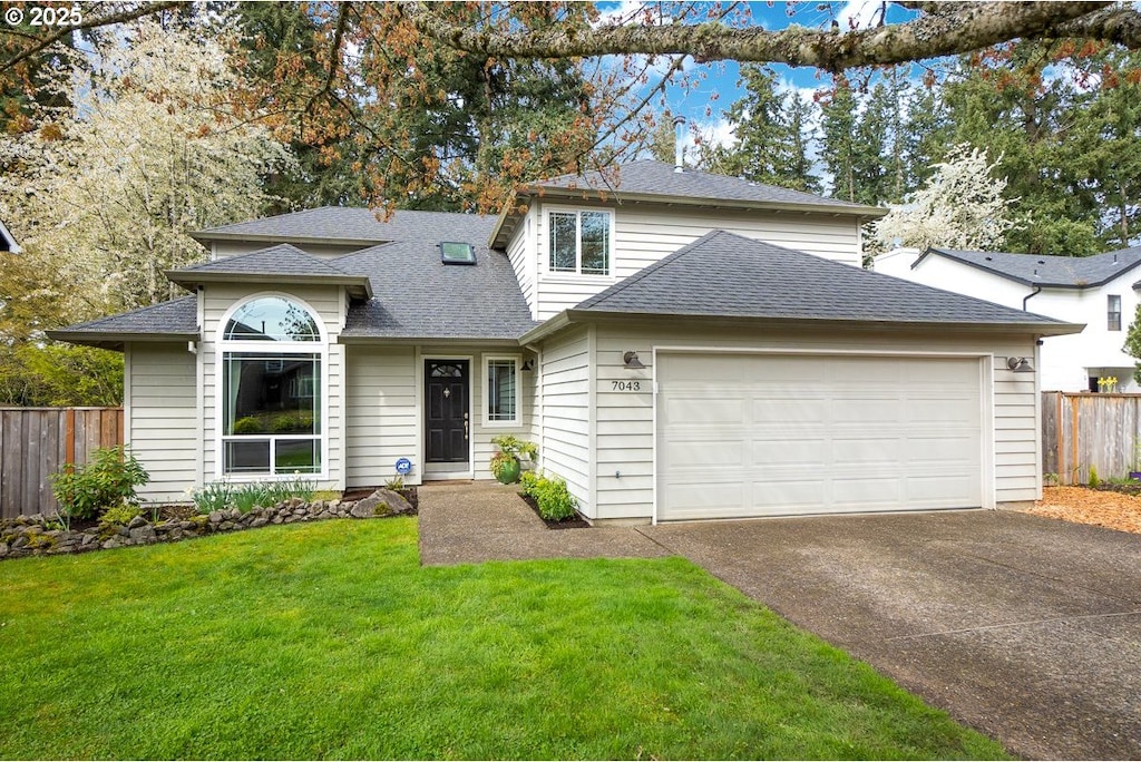 7043 SW 166th Ter, Beaverton, OR 97007 - traditional home featuring concrete driveway, an attached garage, a front yard, fence, and a shingled roof