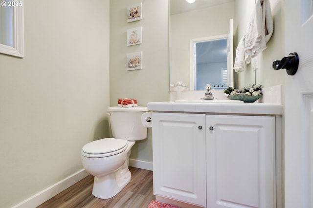 bathroom with hardwood / wood-style flooring, vanity, and toilet