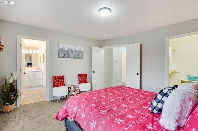 bedroom with ensuite bathroom and carpet floors