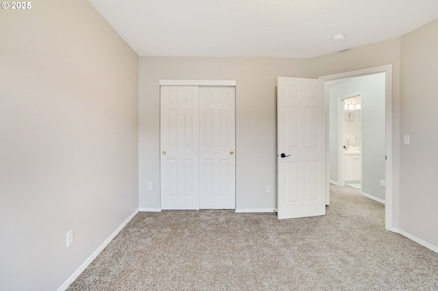 unfurnished bedroom featuring light carpet and a closet