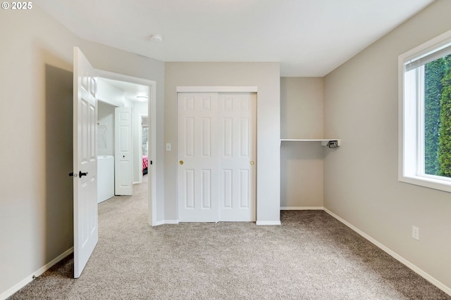 unfurnished bedroom featuring multiple windows, light carpet, and a closet