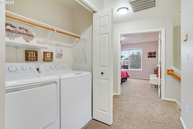 laundry room with light colored carpet and independent washer and dryer