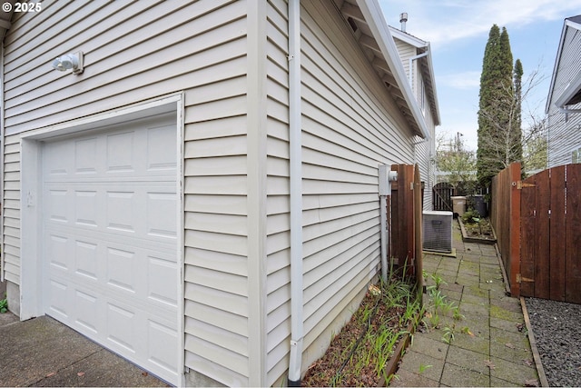 view of property exterior with central air condition unit and a garage