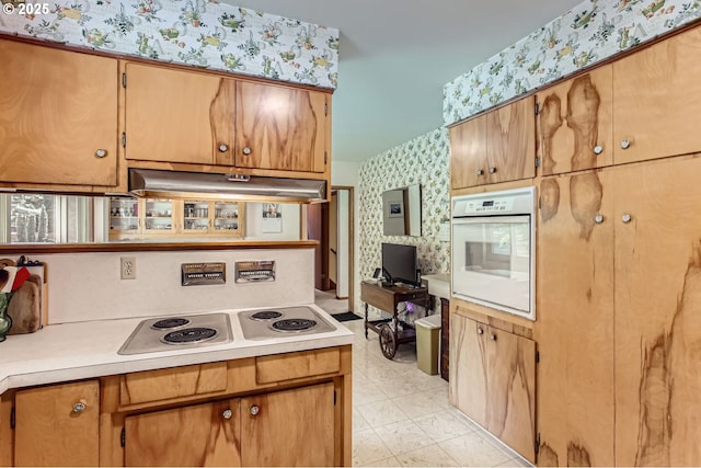14385 SW Hargis Rd, Beaverton, OR 97008 - kitchen with oven, under cabinet range hood, wallpapered walls, electric cooktop, and light countertops
