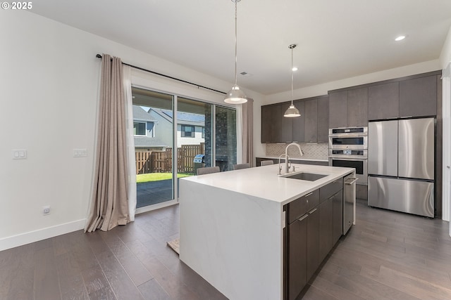 15875 NW Ridgeline St, Portland, OR 97229 - kitchen featuring appliances with stainless steel finishes, dark wood-type flooring, tasteful backsplash, light countertops, and recessed lighting