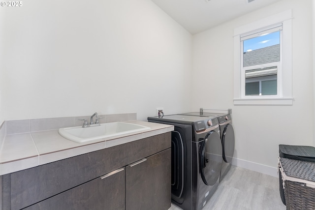 15875 NW Ridgeline St, Portland, OR 97229 - laundry room featuring cabinet space, washing machine and clothes dryer, and light wood finished floors