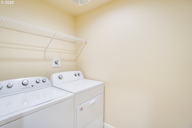 clothes washing area with laundry area, baseboards, visible vents, and washing machine and clothes dryer