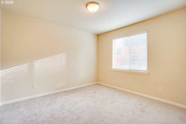 spare room with carpet and baseboards