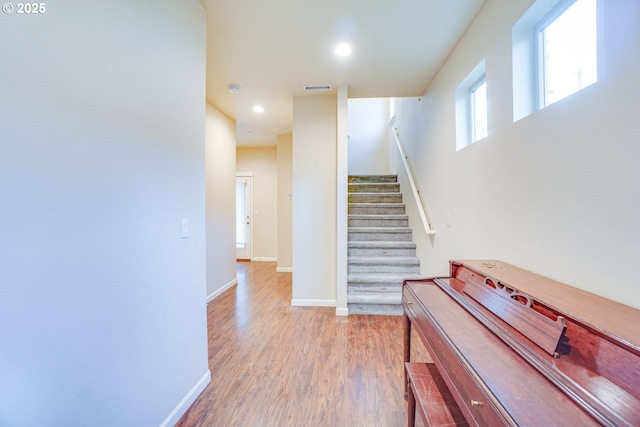 staircase featuring recessed lighting, wood finished floors, visible vents, and baseboards