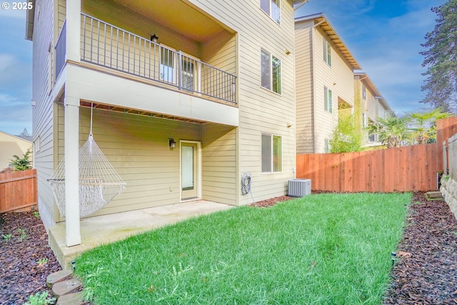 rear view of house featuring a lawn, a patio area, fence, and a balcony