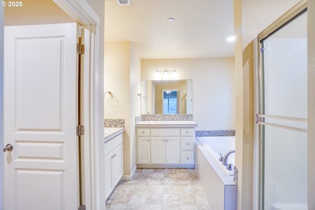 bathroom featuring two vanities, visible vents, a stall shower, a sink, and a bath