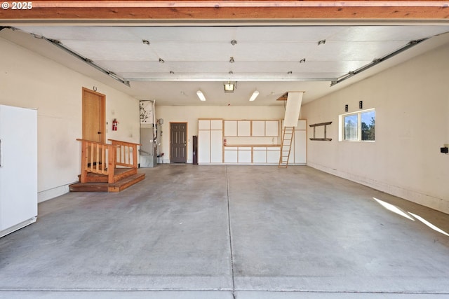 garage featuring a garage door opener and freestanding refrigerator