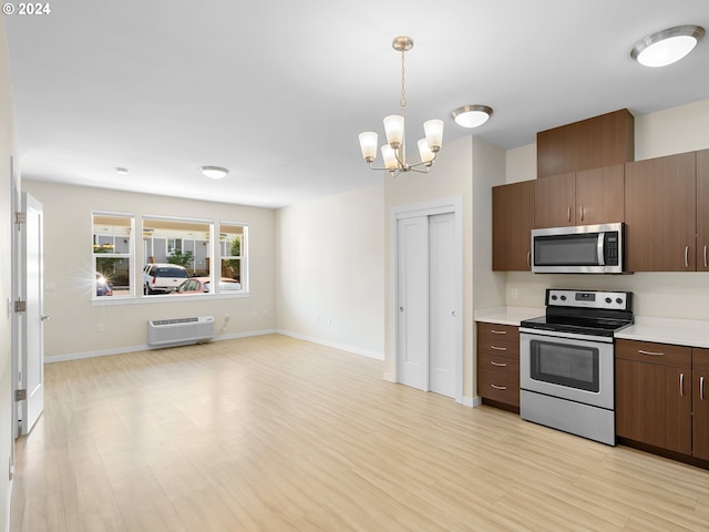 kitchen with an inviting chandelier, a wall mounted air conditioner, decorative light fixtures, stainless steel appliances, and light hardwood / wood-style floors