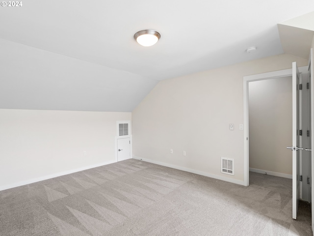 bonus room with light colored carpet and lofted ceiling