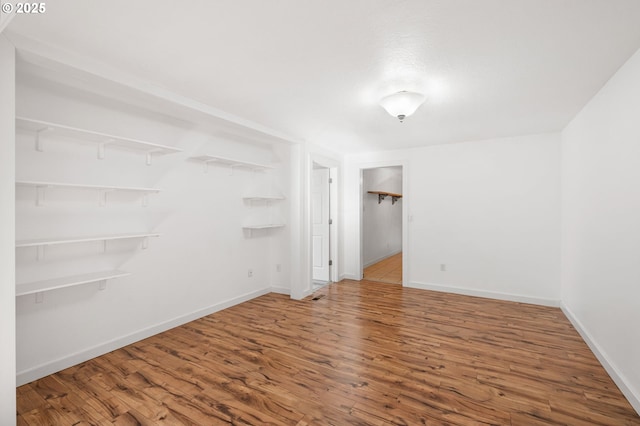 spare room featuring baseboards and wood finished floors