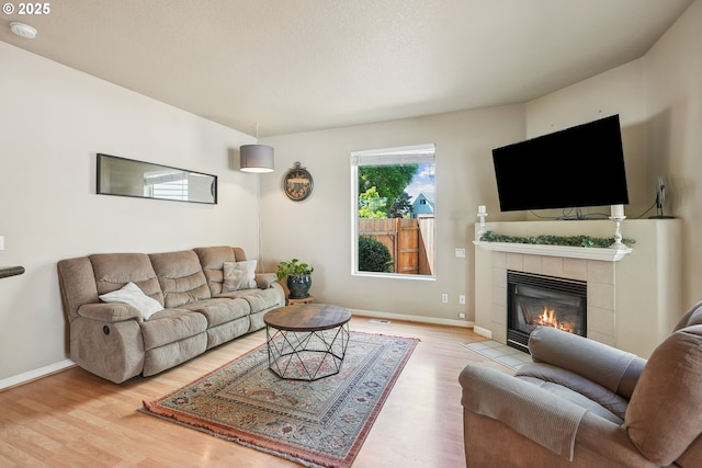 503 NW Hertel St, Hillsboro, OR 97124 - living area with wood finished floors, a tile fireplace, and baseboards