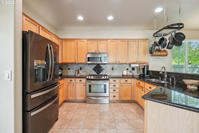 503 NW Hertel St, Hillsboro, OR 97124 - kitchen featuring appliances with stainless steel finishes, a sink, light brown cabinetry, decorative backsplash, and dark stone countertops
