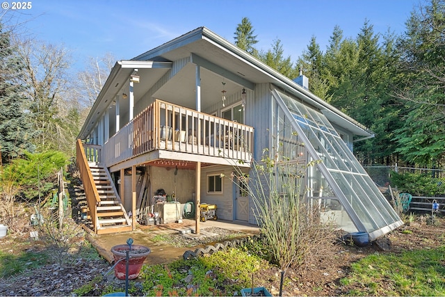 back of property with a wooden deck, stairs, and a chimney