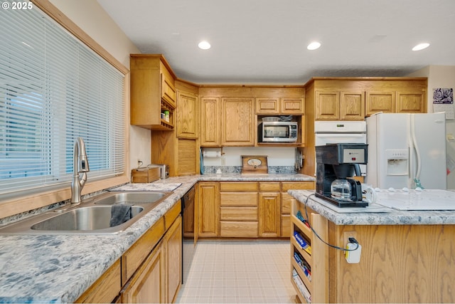 kitchen with a sink, recessed lighting, and white appliances
