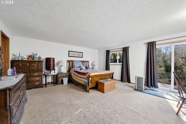 bedroom with radiator, access to outside, light carpet, and a textured ceiling