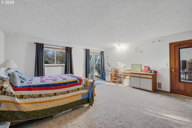 carpeted bedroom featuring a textured ceiling and visible vents