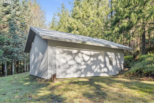 detached garage featuring a view of trees