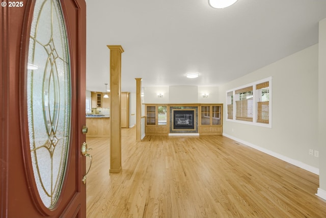 7307 SW Capitol Hwy, Portland, OR 97219 - entryway with a glass covered fireplace, light wood-type flooring, and decorative columns