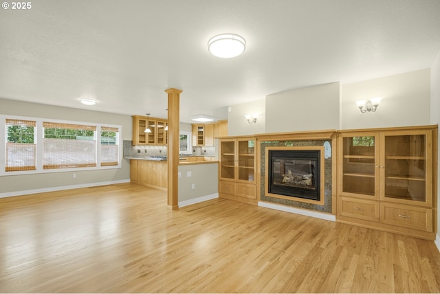 7307 SW Capitol Hwy, Portland, OR 97219 - unfurnished living room featuring light wood-type flooring and a glass covered fireplace