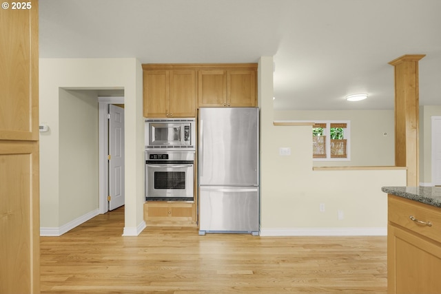 7307 SW Capitol Hwy, Portland, OR 97219 - kitchen featuring stainless steel appliances, light wood-style flooring, and dark stone counters