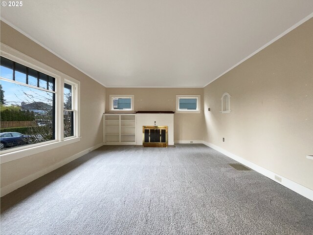 unfurnished living room with ornamental molding and carpet flooring