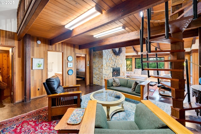 living room featuring wooden walls, dark hardwood / wood-style flooring, a stone fireplace, wooden ceiling, and beamed ceiling